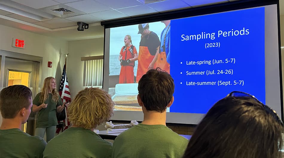 Fellow interns look on as Kendyl Farrell, a sophomore at Virginia Tech, presents the results of her internship research project. Photo credit: Ethan Smith.