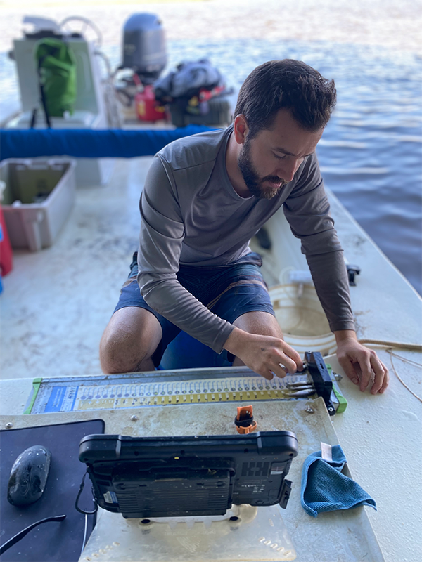 Scientist Jack Buchanan measures juvenile striped bass on the Pamunkey River. © Samantha Dowiarz/VIMS